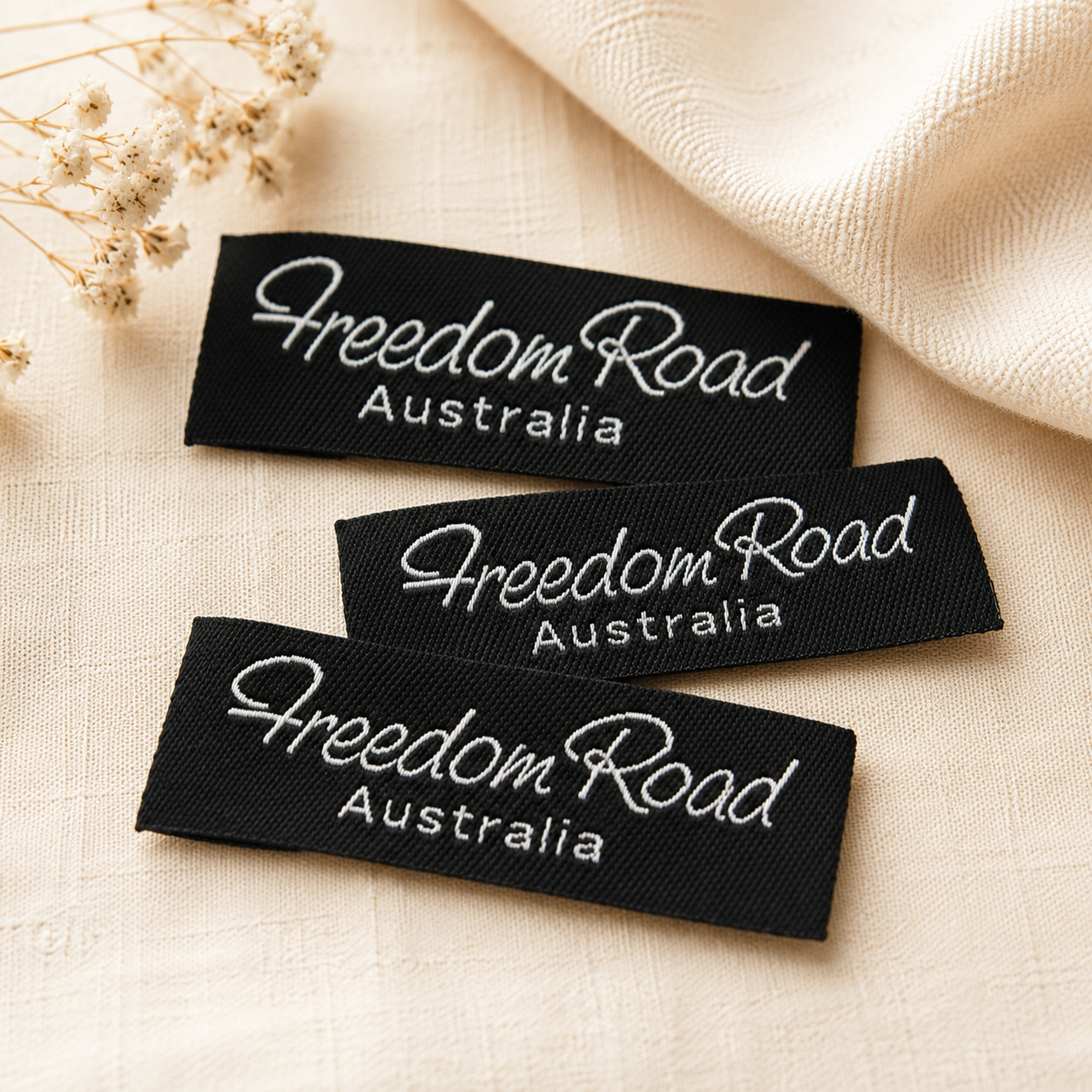 Black custom woven labels on beige fabric for clothing brands