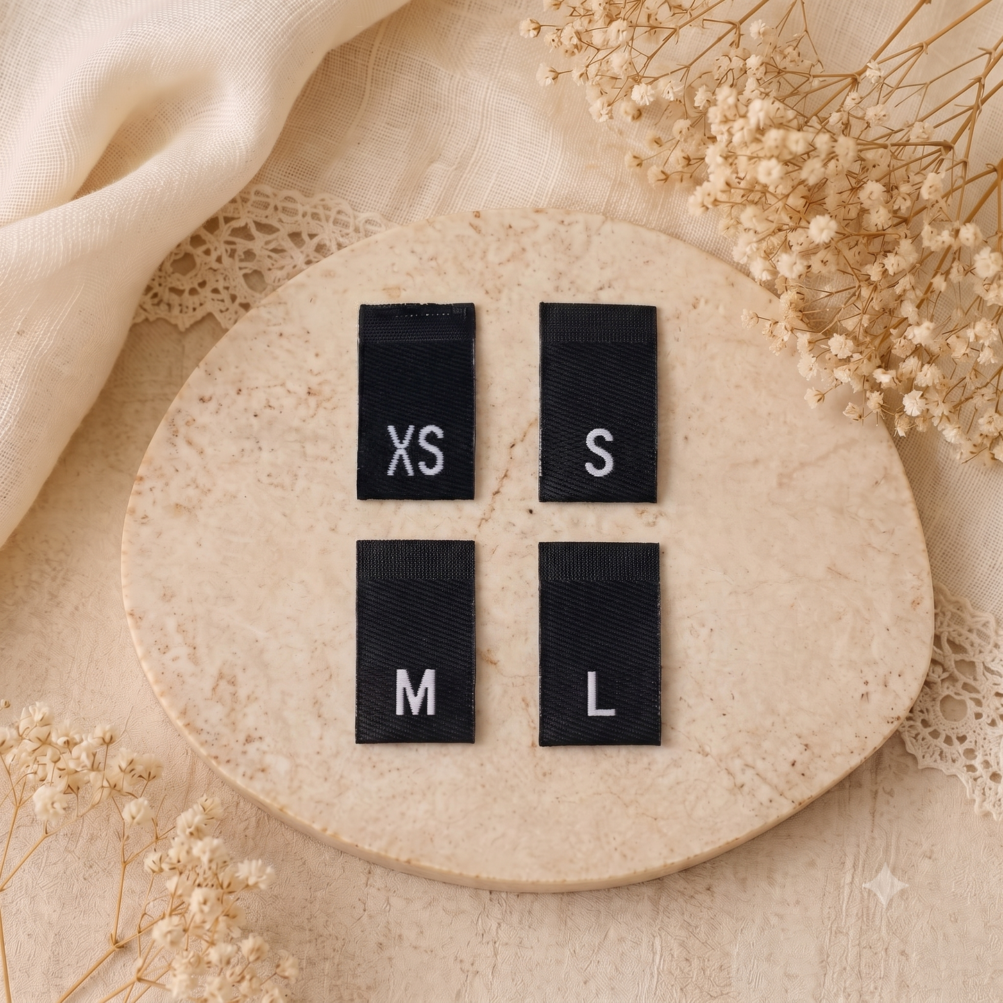Black woven size labels with white XS, S, M and L letters for clothing and handmade garments