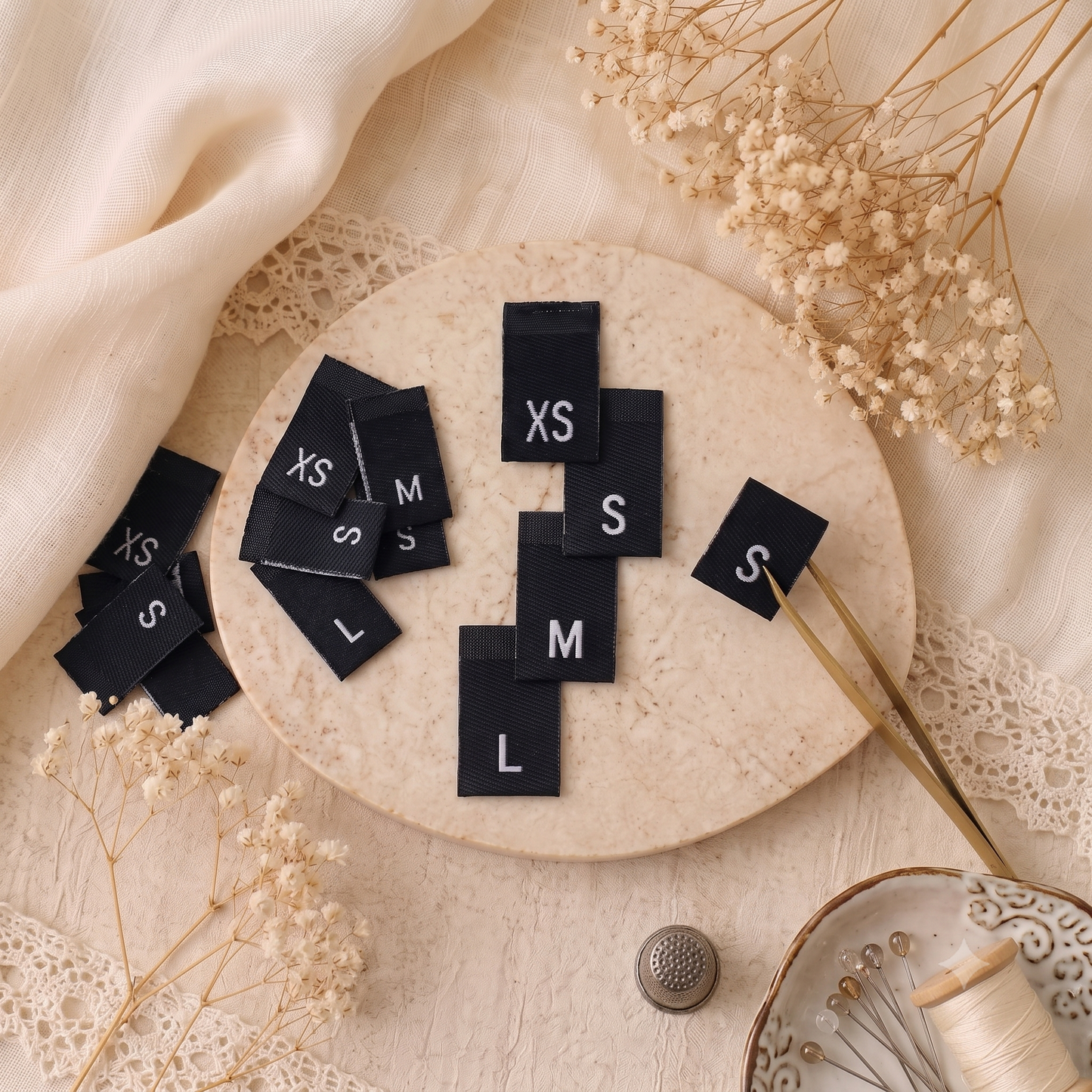 Black woven size labels with white XS, S, M and L letters for clothing and handmade garments